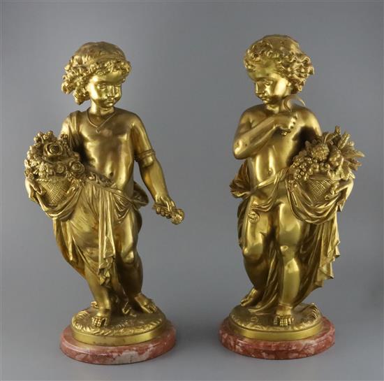 A pair of ormolu figures of putti holding flowers and a sickle, height 20.5in. diameter of bases 8in.